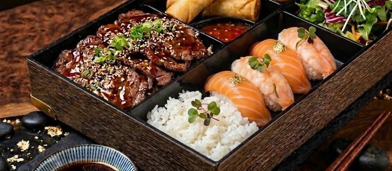 Bento box med teriyaki, gyoza och nigiri